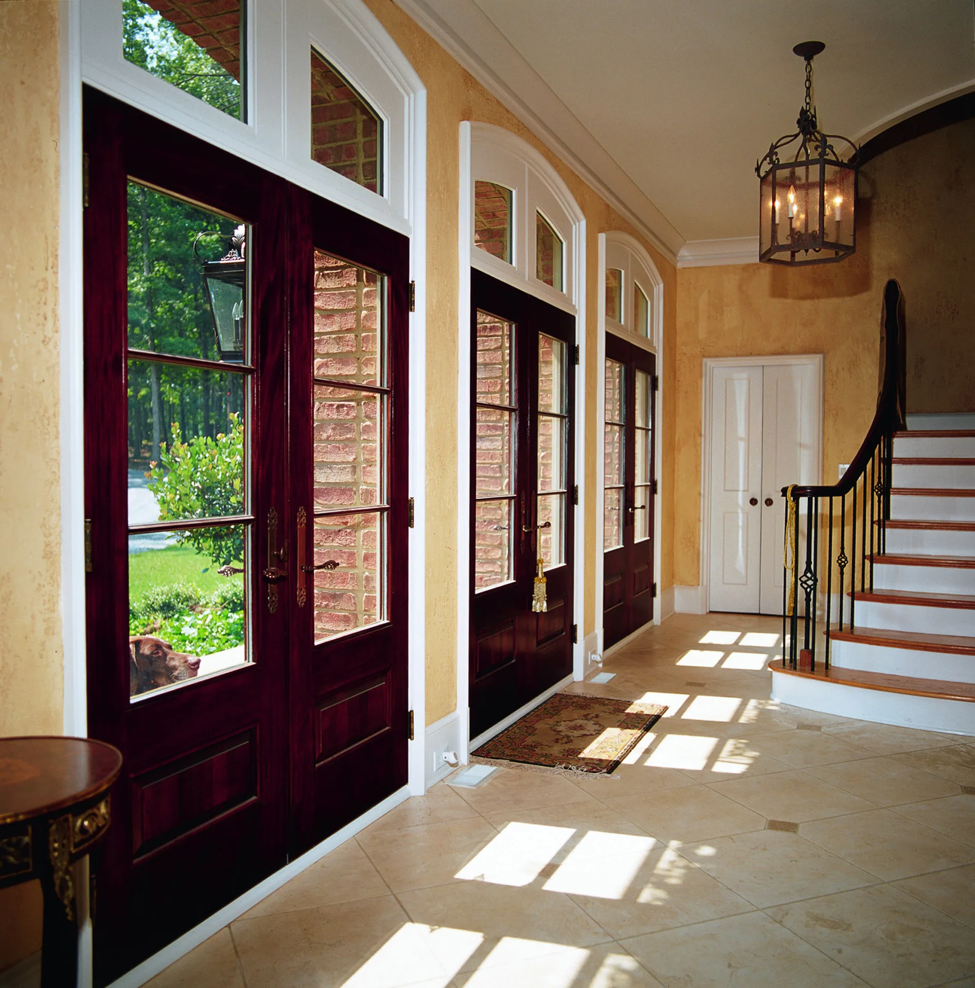 Sunlit run of replacement windows along an interior hallway and stair