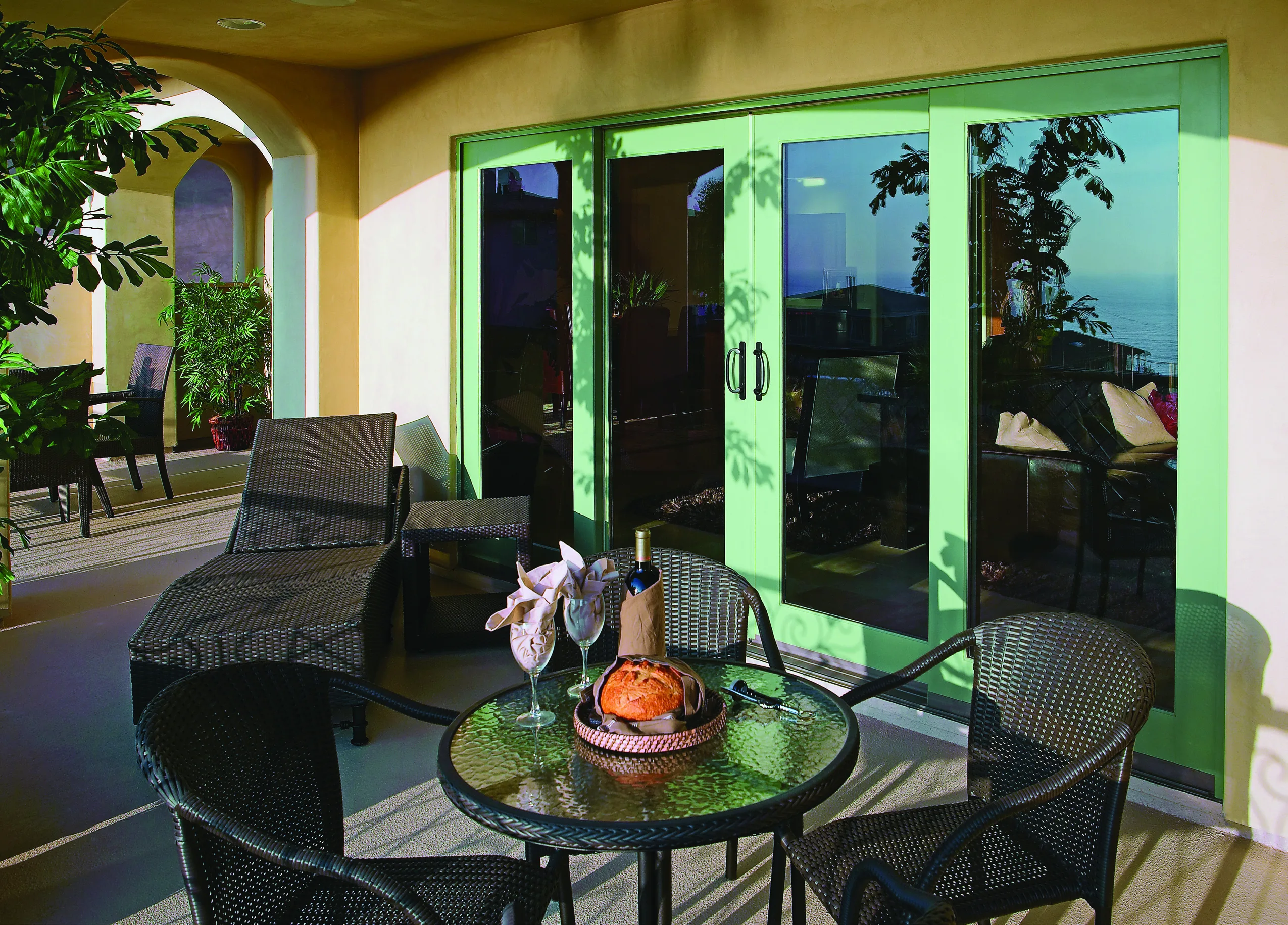 Wide multi-slide glass door opened onto a covered patio and desert landscaping