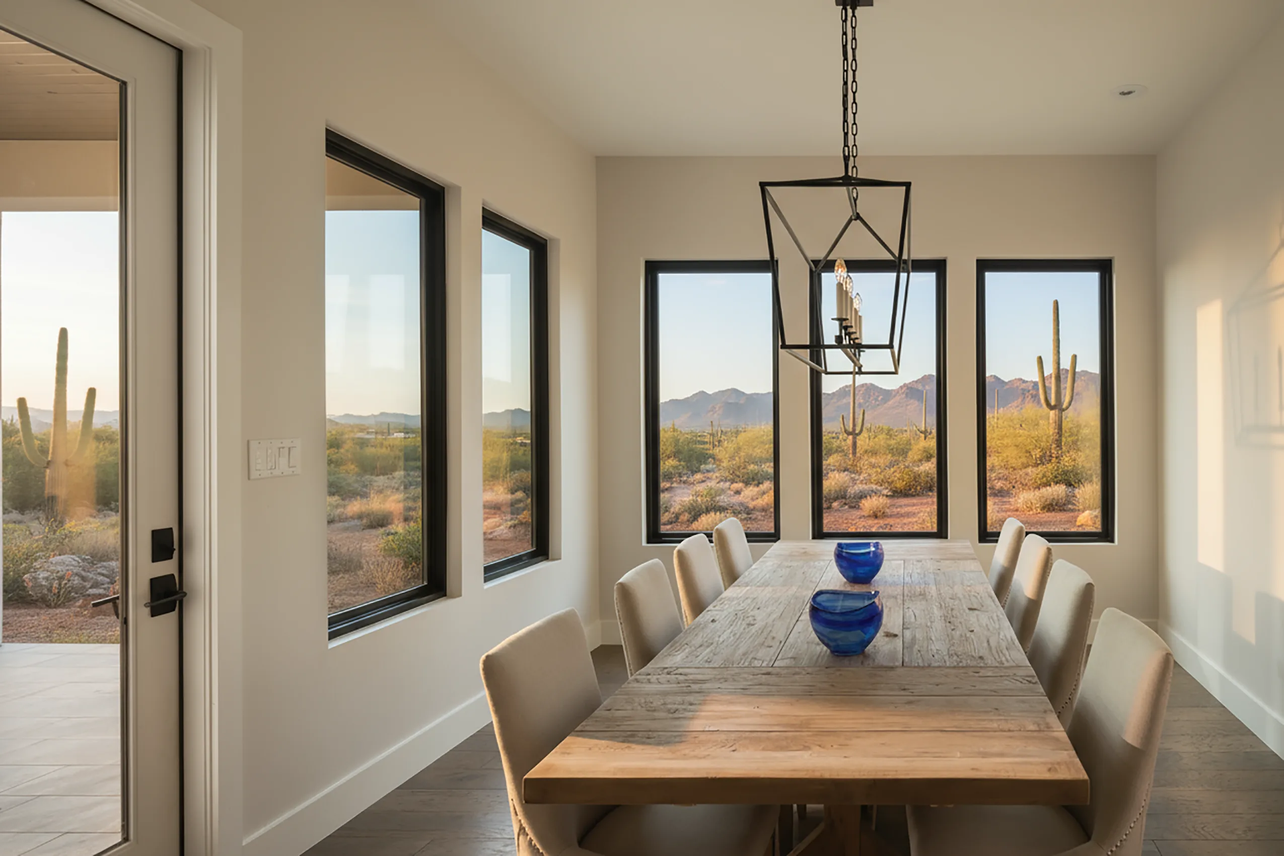 Dining room with black framed windows overlooking the desert