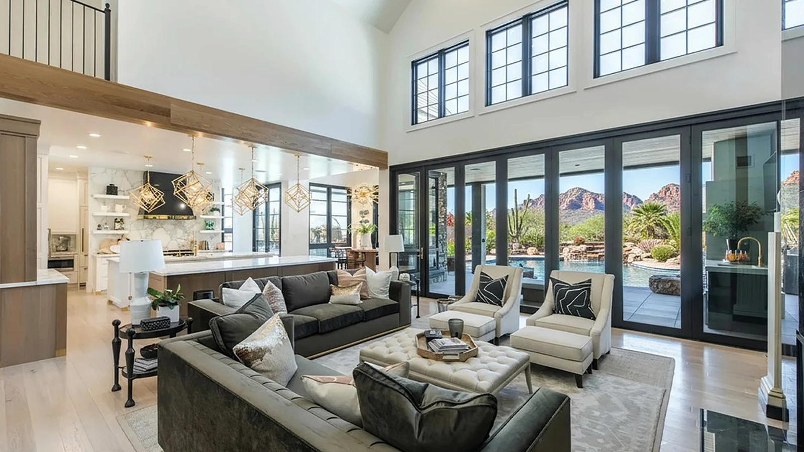 Wall of sliding glass panels, closed, in a great room looking out to a pool and red rock