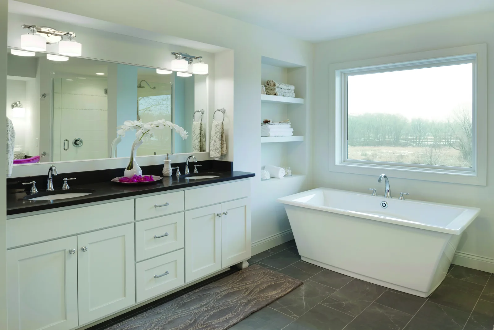 Bathroom with a freestanding tub under a wide white-framed picture window
