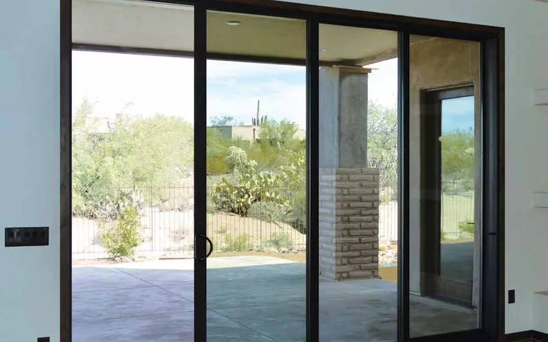 IWC Ambassador dark-framed aluminum sliding glass door opening onto a desert patio