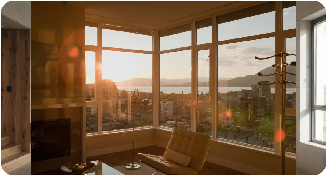 Large windows framing a sunset view from a living room