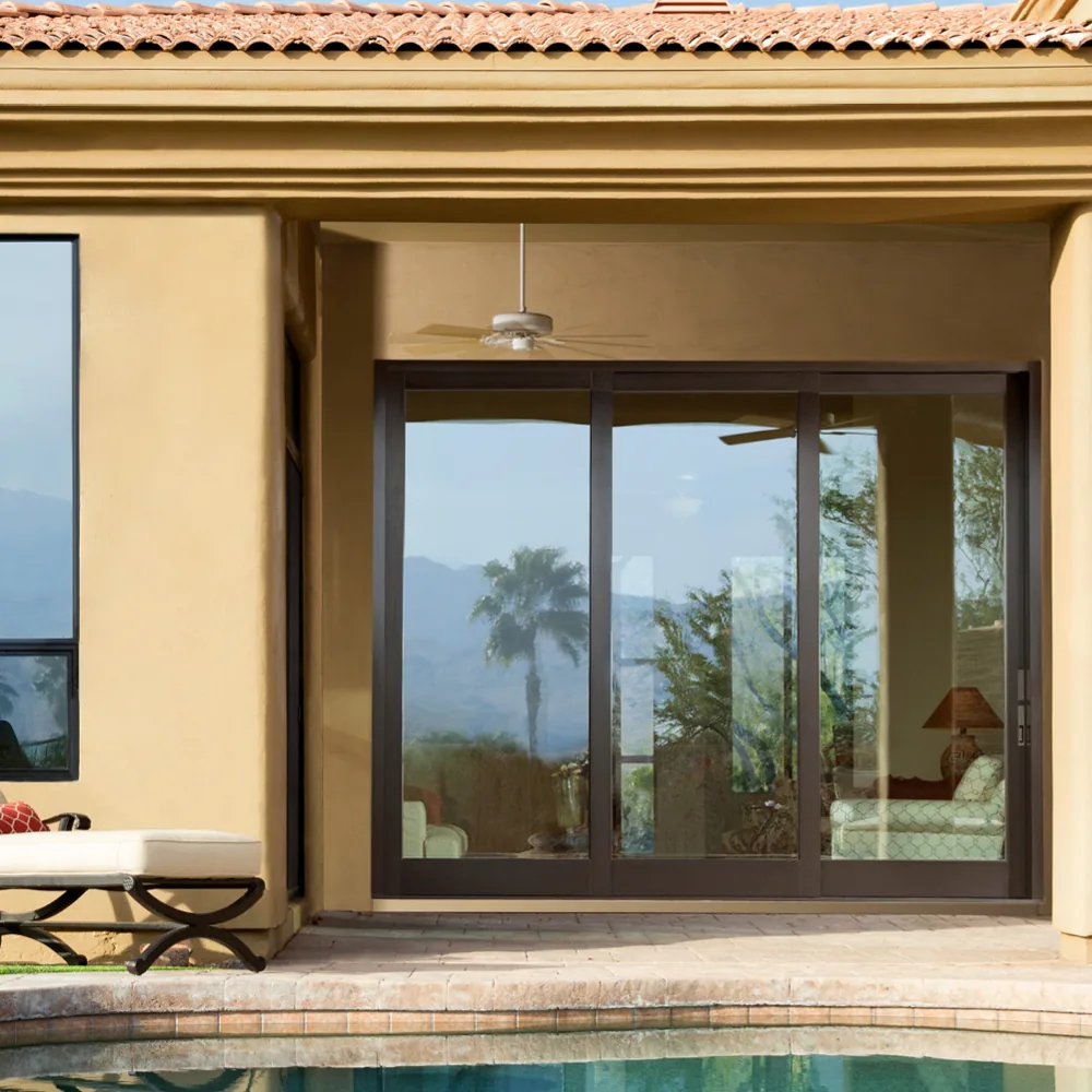 Three panel sliding glass door, closed, under a covered patio beside a pool