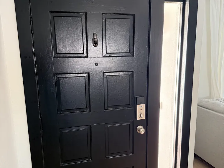 Black panelled entry door with a narrow sidelight on a finished Phoenix home