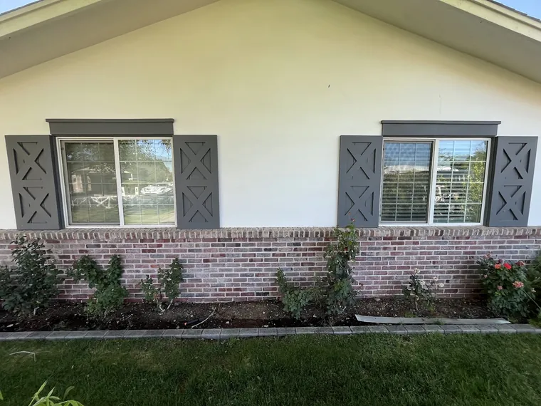 Finished Phoenix new build elevation with black framed windows, decorative shutters and a brick wainscot