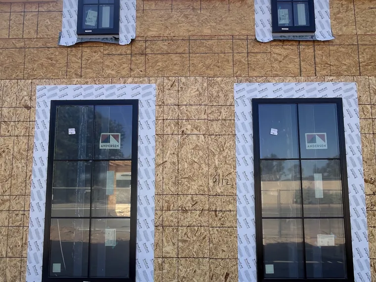 Two story Phoenix new build elevation with black framed windows set into the sheathing