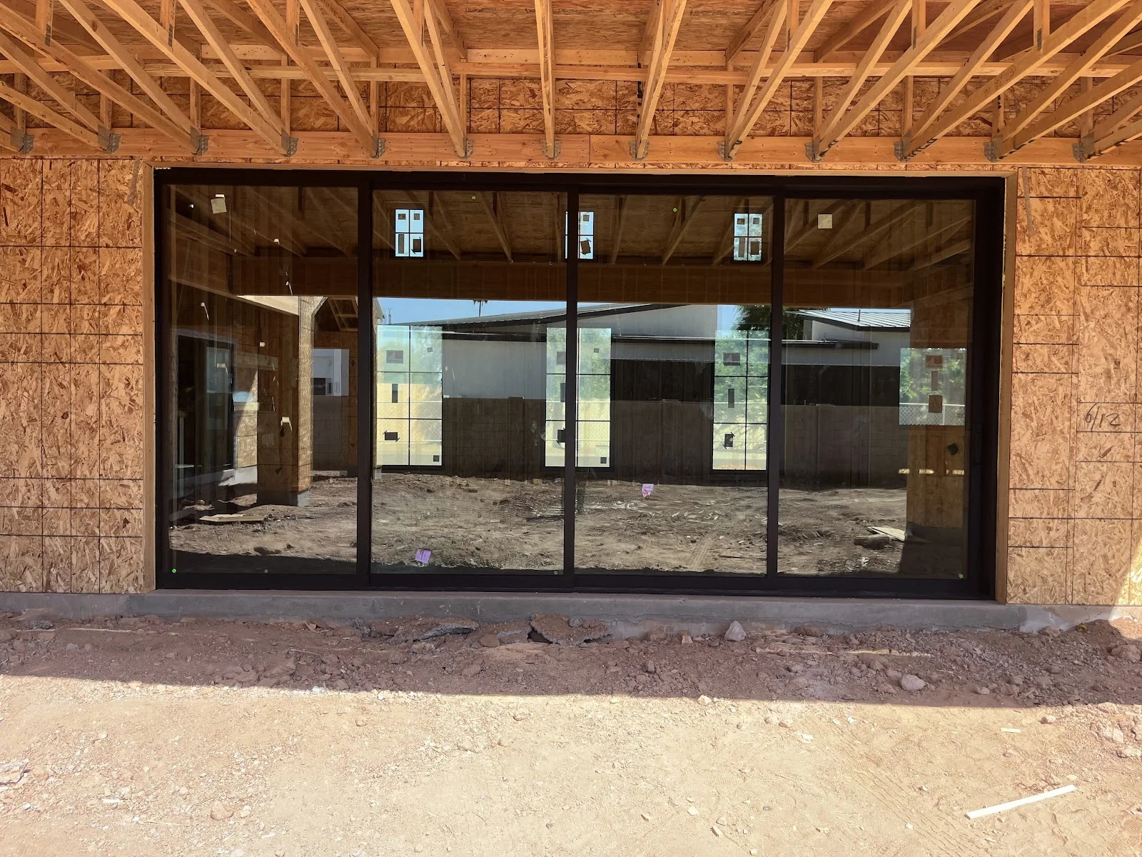 Four panel sliding glass door installed by Noble Windows and Doors in a home under construction, shown closed