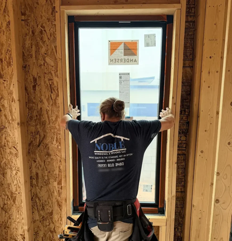 Installer setting a new Andersen window into a framed rough opening