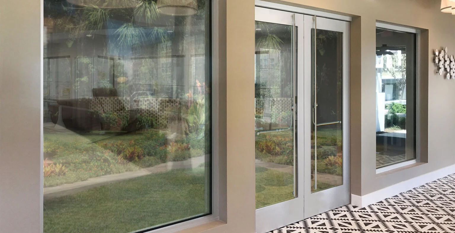 PRL clear anodized aluminum doors and fixed glass along a courtyard