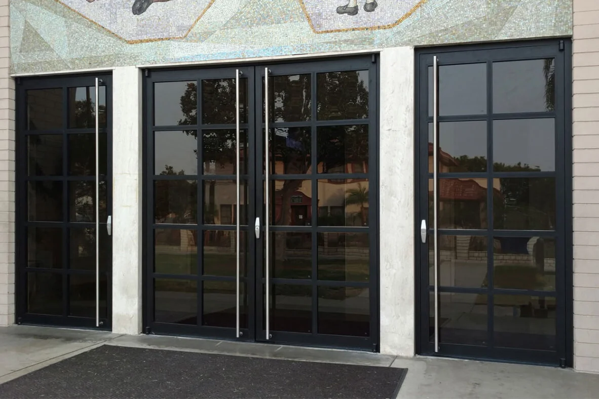 Row of PRL Glass Systems black aluminum doors with divided glass and full-height pulls at a building entrance