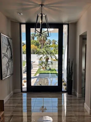 PRL Glass Systems medium stile aluminum entry door, full glass, seen from a marble foyer