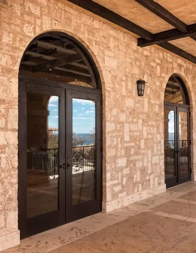 PRL Glass Systems wide stile aluminum doors under a stone arch
