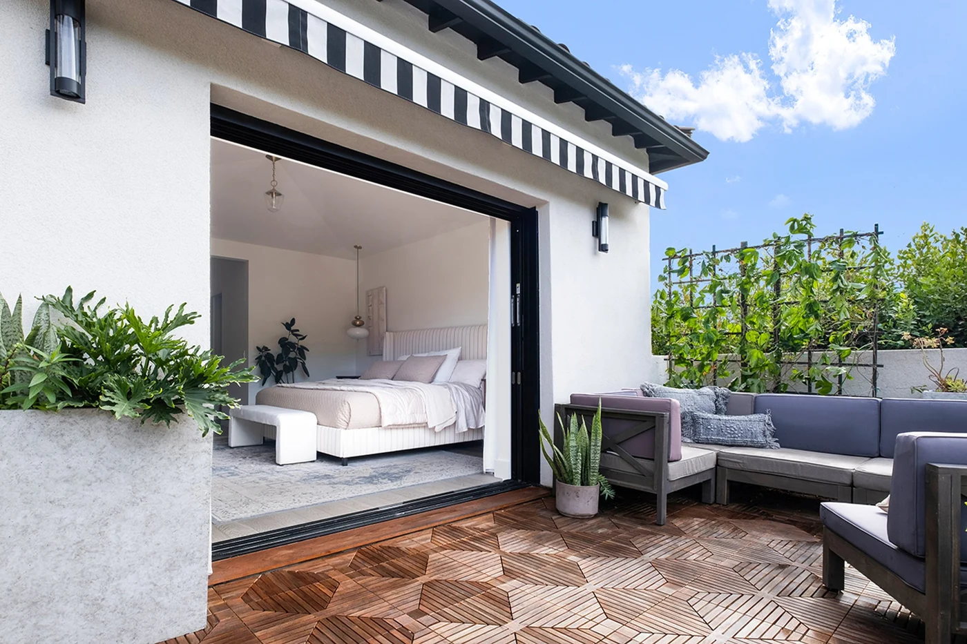 Stacking door open from a bedroom onto a tiled patio, panels parked at the right jamb